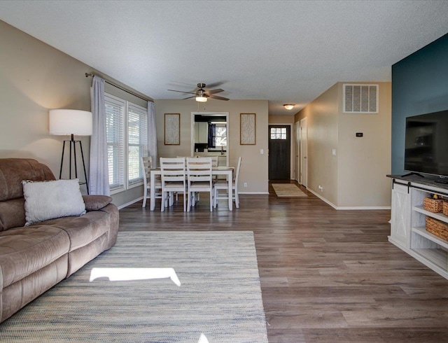 living room with ceiling fan, hardwood / wood-style floors, and a textured ceiling