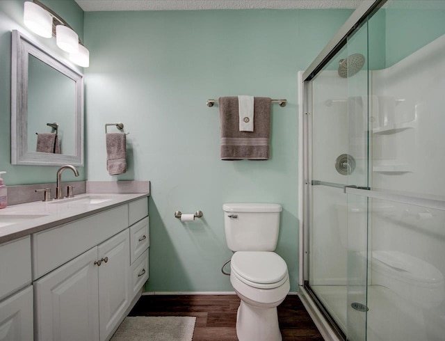 bathroom featuring walk in shower, toilet, a textured ceiling, vanity, and hardwood / wood-style floors