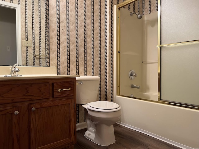 full bathroom with vanity, hardwood / wood-style flooring, combined bath / shower with glass door, and toilet