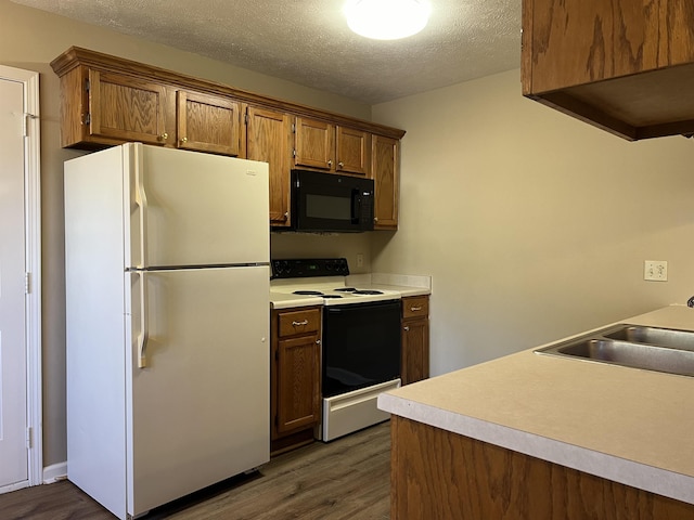 kitchen featuring dark wood-type flooring, sink, electric range oven, a textured ceiling, and white refrigerator