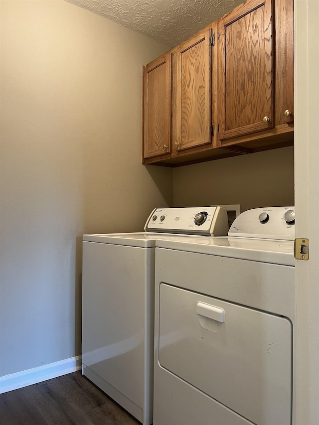 laundry area with separate washer and dryer, dark hardwood / wood-style floors, cabinets, and a textured ceiling