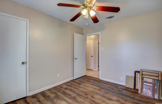 8 Woodmere Pl, Sherwood, AR 72120 - unfurnished bedroom with hardwood / wood-style floors, a textured ceiling, and ceiling fan