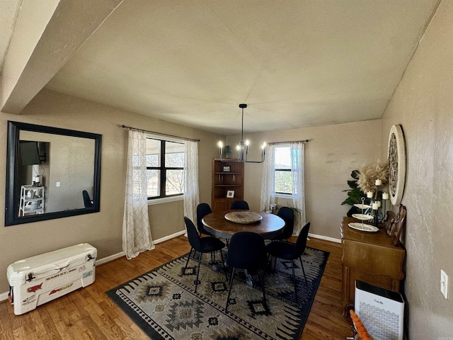 dining space featuring hardwood / wood-style floors and a notable chandelier