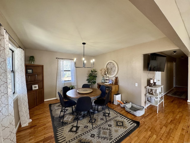 dining space featuring hardwood / wood-style flooring and a notable chandelier