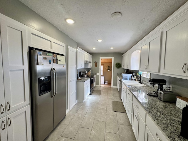 kitchen featuring range with electric stovetop, white cabinetry, stainless steel refrigerator with ice dispenser, light stone countertops, and a textured ceiling