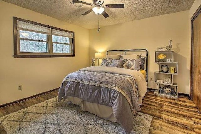 bedroom with wood-type flooring, a textured ceiling, and ceiling fan