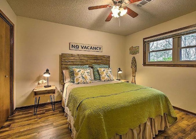 bedroom featuring hardwood / wood-style floors, a textured ceiling, ceiling fan, and a closet