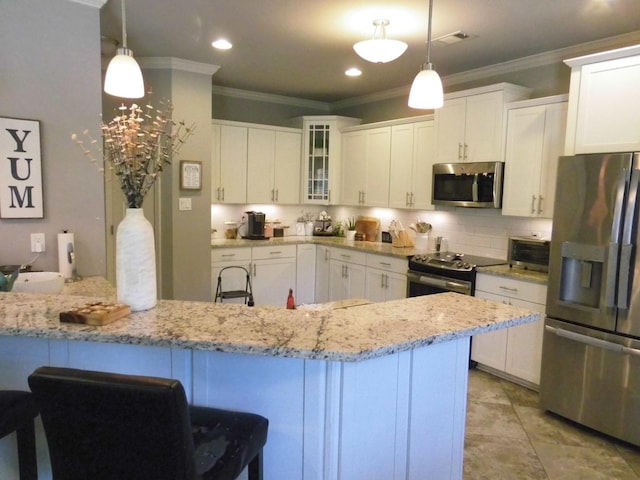 kitchen featuring stainless steel appliances, decorative backsplash, white cabinets, and decorative light fixtures