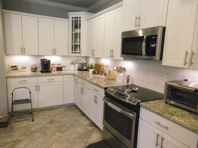 kitchen featuring appliances with stainless steel finishes, light stone counters, white cabinets, and backsplash