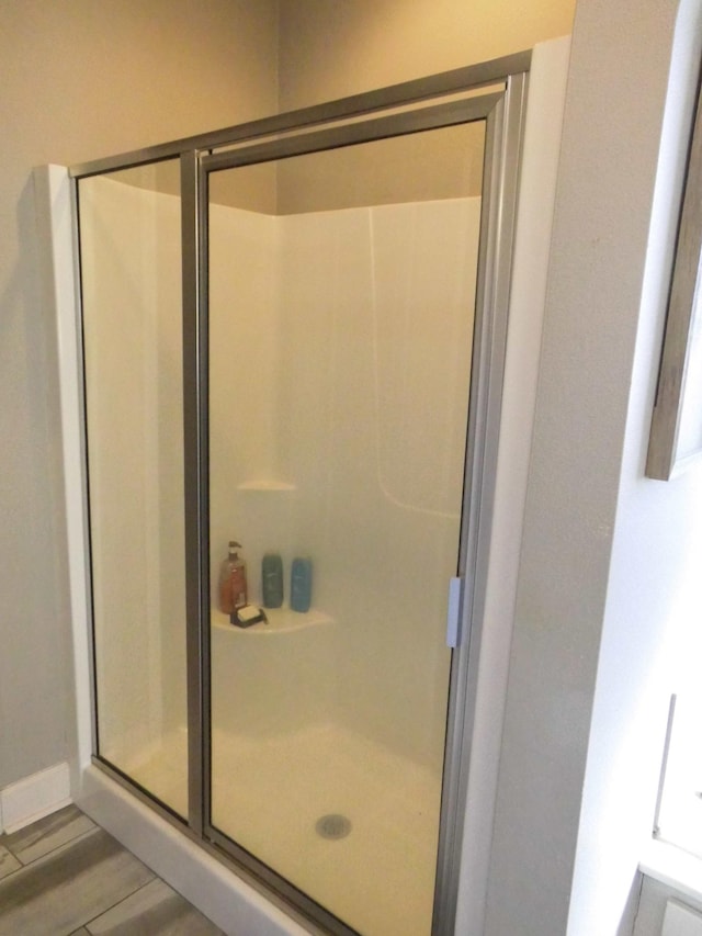 bathroom featuring a shower with door and hardwood / wood-style floors