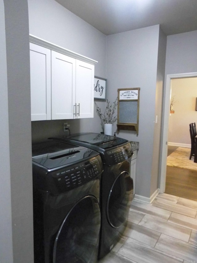 washroom with separate washer and dryer and cabinets