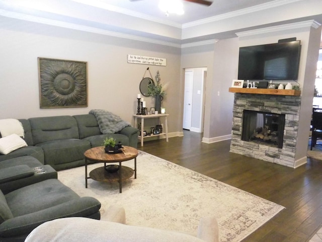 living room featuring dark wood-type flooring, a fireplace, crown molding, and ceiling fan