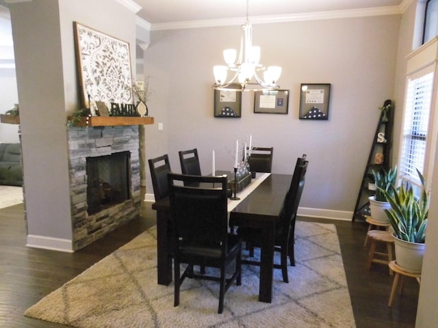 dining space featuring an inviting chandelier, a fireplace, ornamental molding, and dark hardwood / wood-style floors