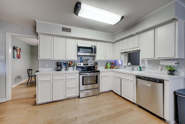 kitchen with sink, white cabinetry, crown molding, light wood-type flooring, and stainless steel appliances