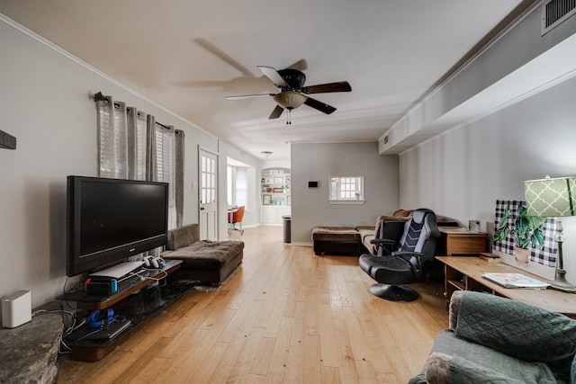 living room featuring hardwood / wood-style flooring, ornamental molding, and ceiling fan