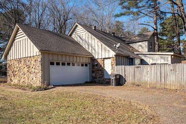 view of side of property featuring a garage and a lawn