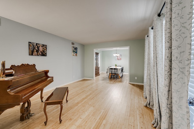 misc room with hardwood / wood-style floors and a chandelier