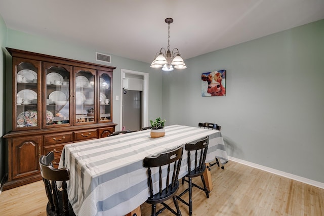 dining room featuring an inviting chandelier and light hardwood / wood-style flooring