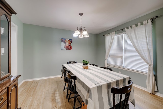 dining space featuring a notable chandelier and light hardwood / wood-style floors