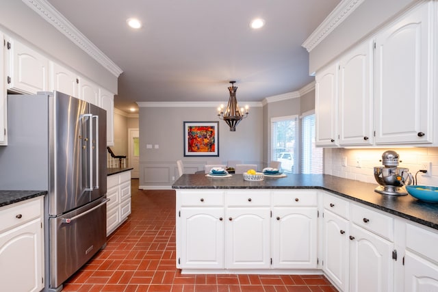 kitchen featuring white cabinetry, high end refrigerator, and decorative light fixtures