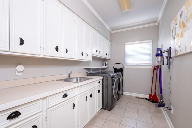 laundry room featuring sink, crown molding, light tile patterned floors, cabinets, and separate washer and dryer