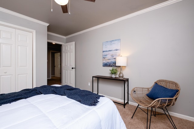 carpeted bedroom featuring ornamental molding, ceiling fan, and a closet