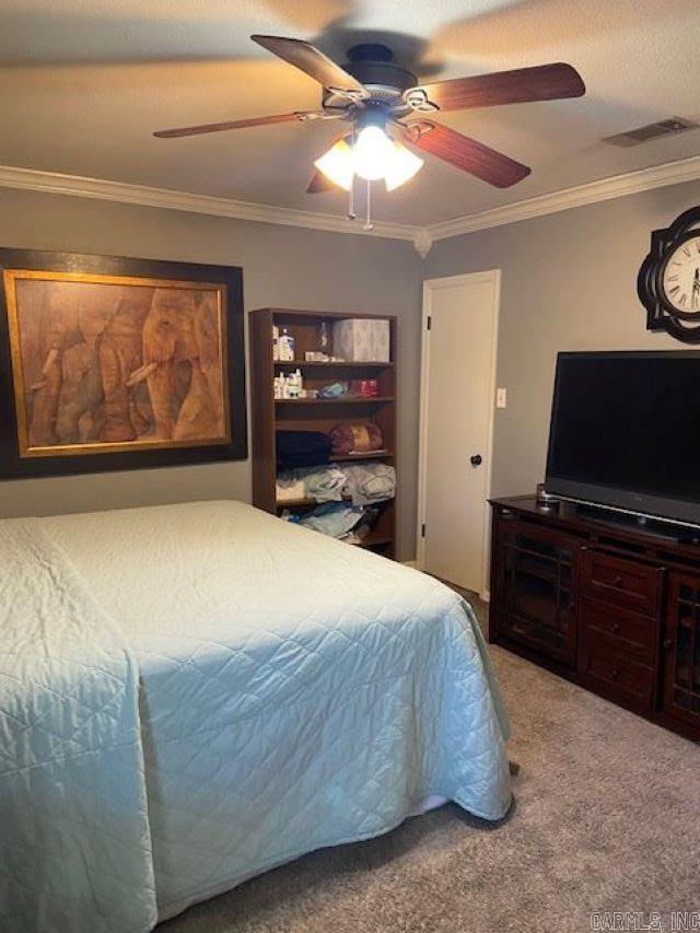 carpeted bedroom with crown molding and ceiling fan