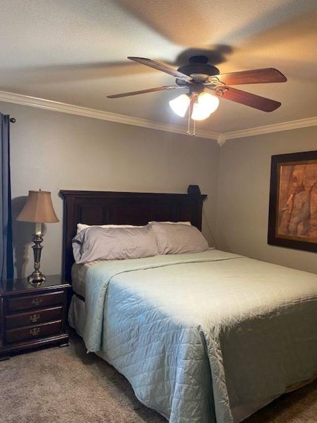 bedroom featuring ceiling fan, ornamental molding, carpet, and a textured ceiling