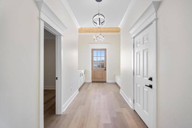 doorway featuring ornamental molding and light wood-type flooring