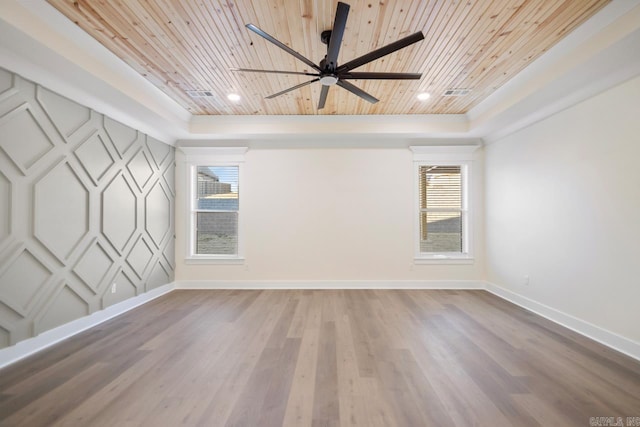 spare room featuring wood-type flooring, wooden ceiling, and a tray ceiling