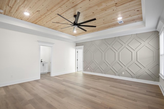 spare room featuring light hardwood / wood-style flooring, wooden ceiling, a raised ceiling, and ceiling fan