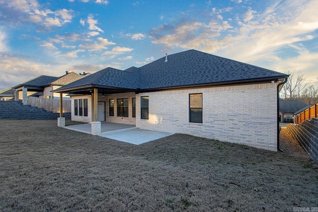 back of house with a patio and a lawn