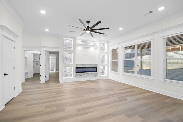 unfurnished living room with ceiling fan, ornamental molding, and light hardwood / wood-style flooring