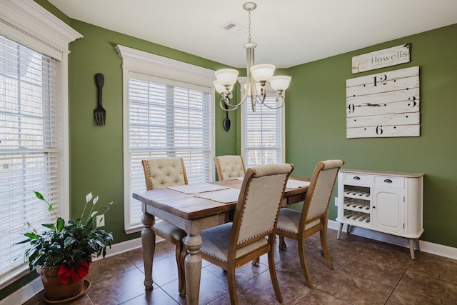 tiled dining room with an inviting chandelier