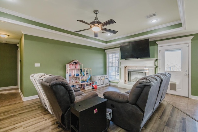 living room with hardwood / wood-style flooring, a wealth of natural light, and ornamental molding