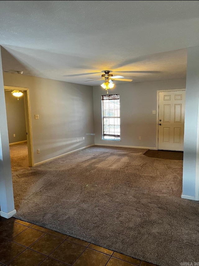 spare room featuring ceiling fan and dark tile patterned flooring