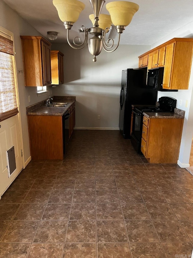 kitchen with sink, a chandelier, dark tile patterned floors, black appliances, and plenty of natural light