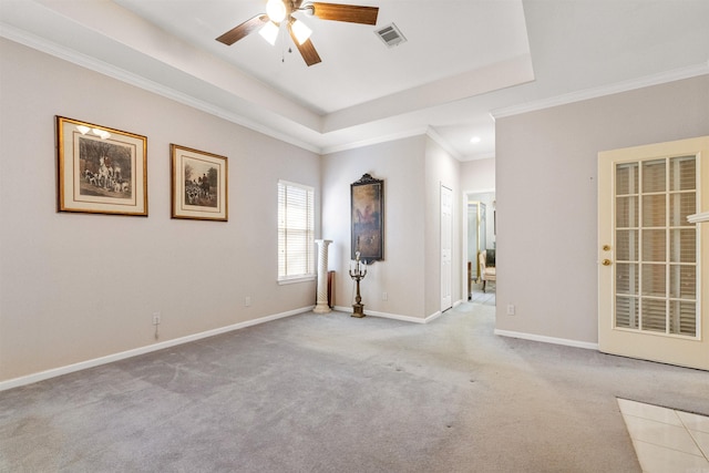 unfurnished room featuring a raised ceiling, light colored carpet, and ceiling fan