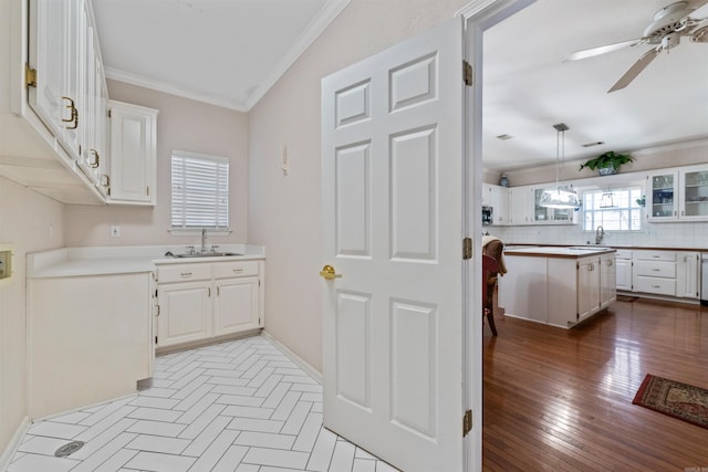 kitchen with white cabinetry, crown molding, tasteful backsplash, and a center island