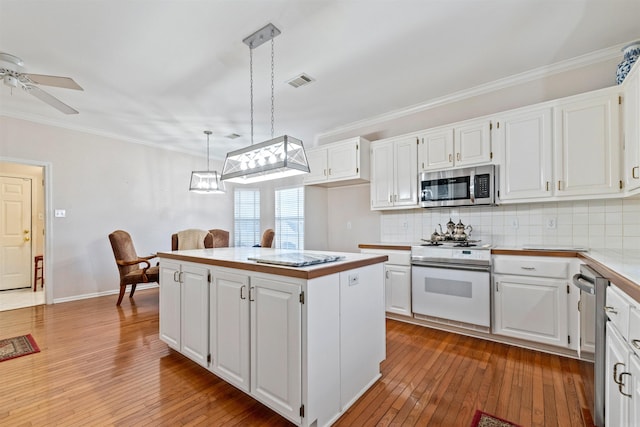 kitchen with pendant lighting, white cabinets, and appliances with stainless steel finishes