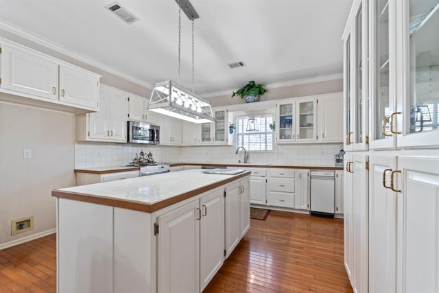 kitchen with hanging light fixtures, a kitchen island, and white cabinets