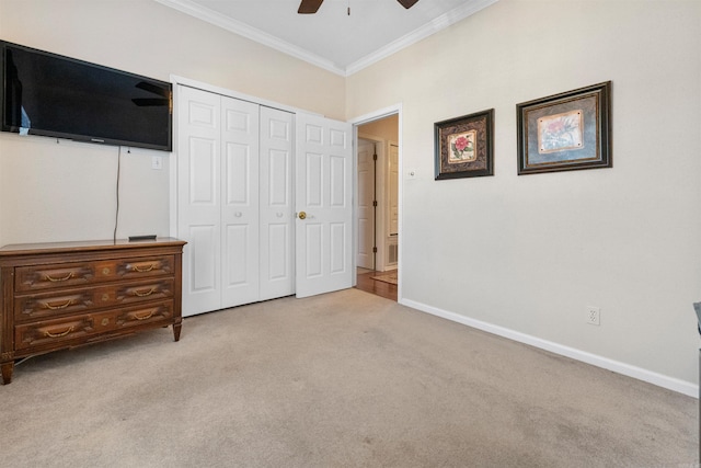 unfurnished bedroom with light carpet, ornamental molding, a closet, and ceiling fan