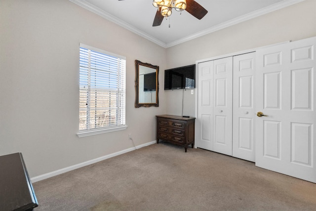 unfurnished bedroom featuring ornamental molding, light colored carpet, a closet, and ceiling fan