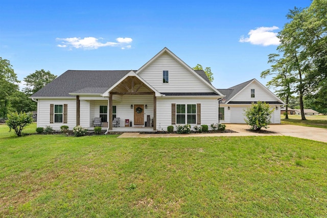 view of front of house with a garage, a front lawn, and covered porch