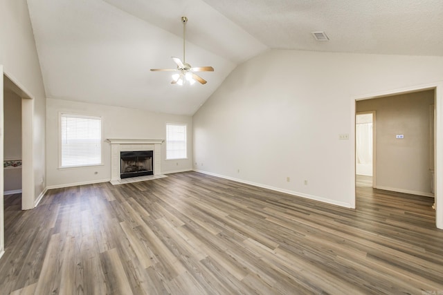 unfurnished living room with ceiling fan, lofted ceiling, a fireplace, and dark hardwood / wood-style flooring