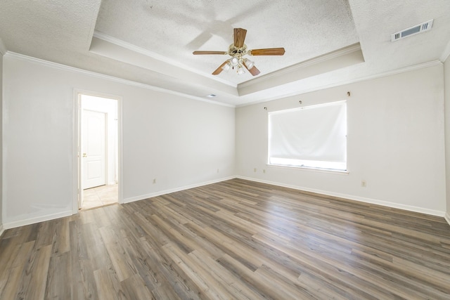 unfurnished room featuring wood-type flooring, ornamental molding, and a raised ceiling