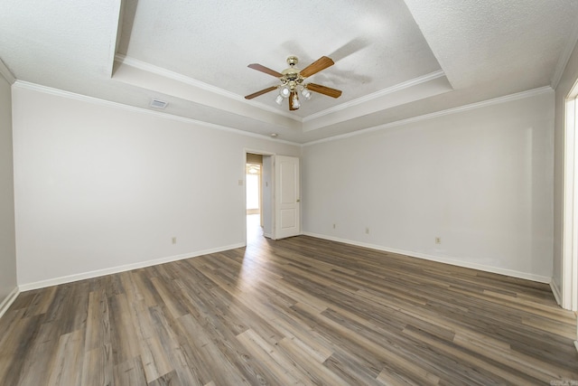 spare room with crown molding, a textured ceiling, dark hardwood / wood-style flooring, a raised ceiling, and ceiling fan