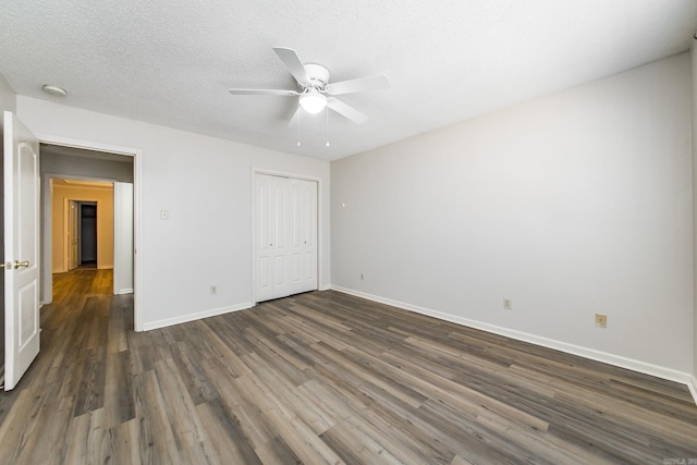 unfurnished bedroom featuring dark wood-type flooring, ceiling fan, a closet, and a textured ceiling