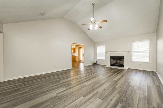 unfurnished living room featuring a tiled fireplace, wood-type flooring, and ceiling fan