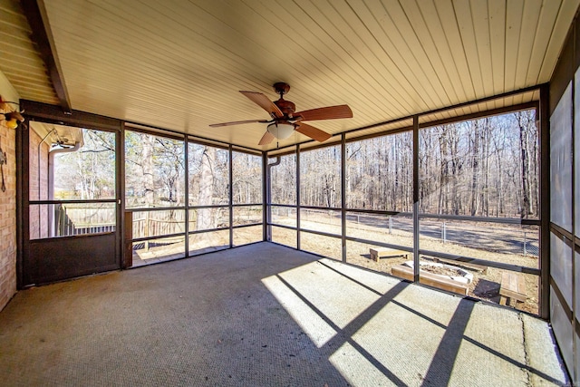 unfurnished sunroom with ceiling fan